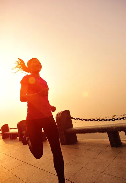 木製の橋の海辺を走るスポーツ女性 — ストック写真