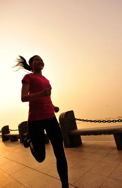 Sports woman running on wooden bridge seaside — Stock Photo, Image