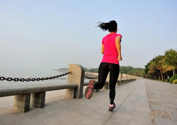 Sports woman running on wooden bridge seaside — Stock Photo, Image