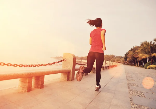 Sports woman running on wooden bridge seaside — Stock Photo, Image