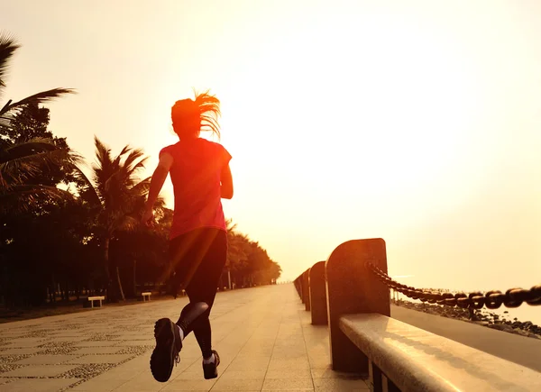 Sports woman running on wooden bridge seaside — Stock Photo, Image