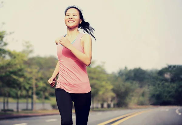 Sporty woman jogging at tropical park — Stock Photo, Image