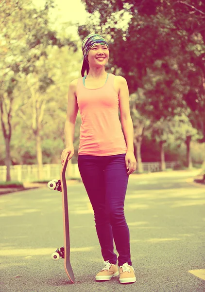 Vrouw skateboard in handen houden — Stockfoto