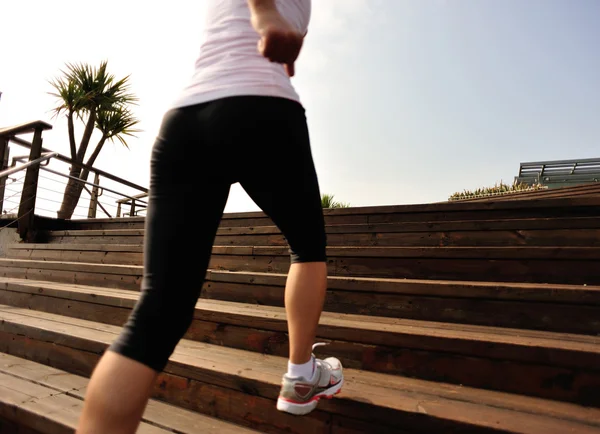 Corredor atleta corriendo en escaleras de piedra junto al mar —  Fotos de Stock