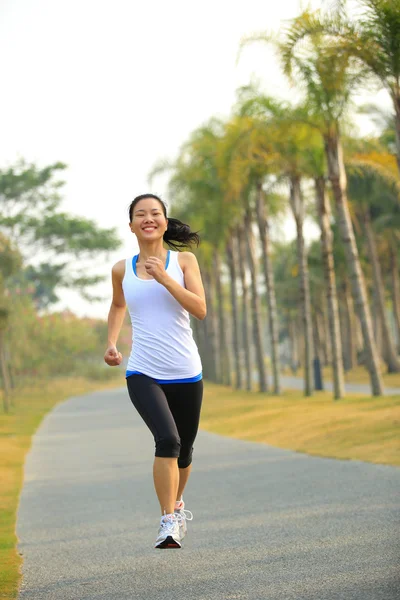 Atleta corredor correndo na estrada do parque tropical — Fotografia de Stock