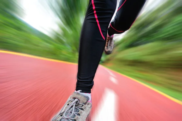 Vrouw loper atleet benen uitgevoerd op weg — Stockfoto