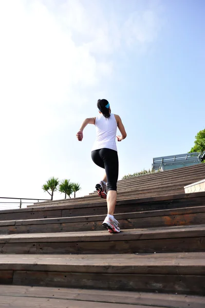 Спортсмен бегущий по приморской каменной лестнице — стоковое фото