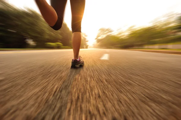 Спортсмен бегущий по дороге восхода солнца — стоковое фото