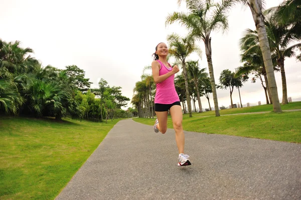 Atleta corredor corriendo en el parque tropical . — Foto de Stock