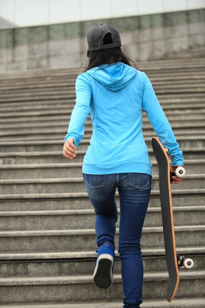 Frau läuft mit Skateboard in der Hand — Stockfoto
