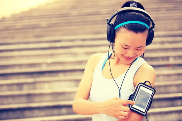 Runner athlete listening to music in headphones — Stock Photo, Image