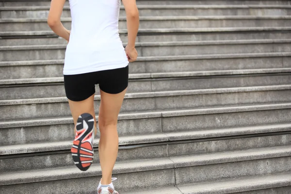 Atleta corredor correndo em escadas ouvindo música — Fotografia de Stock