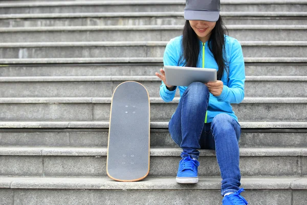 Skateboarder mujer uso tableta digital —  Fotos de Stock