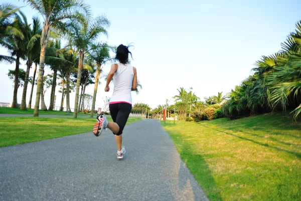 Atleta corredor correndo no parque tropical . — Fotografia de Stock