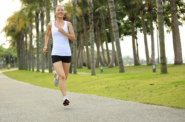 Vrouw uitgevoerd op tropische park trail. — Stockfoto