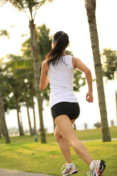 Mujer corriendo en el sendero del parque tropical . — Foto de Stock