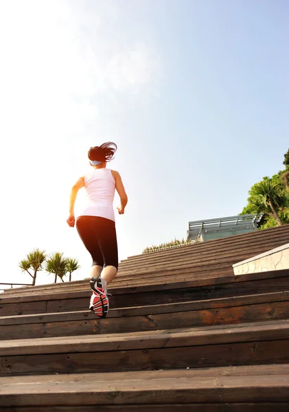 Woman athlete running at stairs