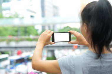 Kadın akıllı telefonla fotoğraf çekiyor.