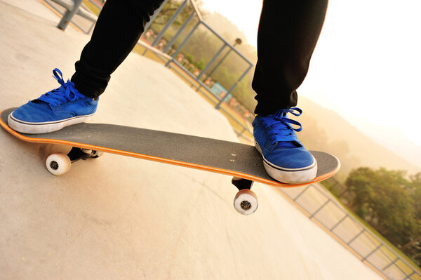 Feet in blue shoes skateboarding