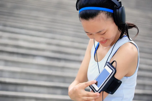 Mulher atleta ouvir música em fones de ouvido — Fotografia de Stock