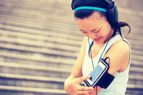 Woman athlete listening to music in headphones — Stock Photo, Image