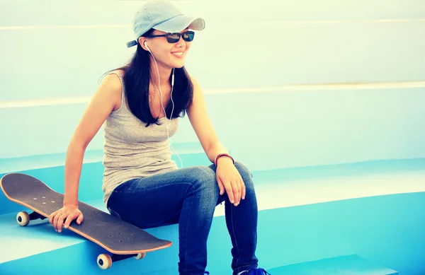 Woman skateboarder listening music — Stock Photo, Image