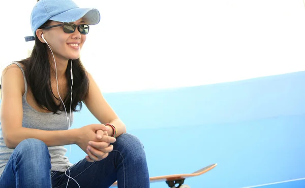 Femme skateboarder écouter de la musique — Photo