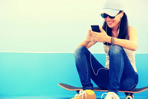 Skateboarderin hört Musik — Stockfoto