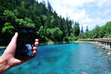 Woman tourist taking photo with smart phone clipart