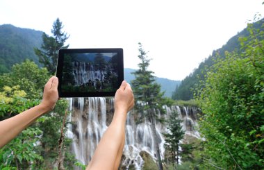 Woman tourist hand taking photo with digital tablet clipart