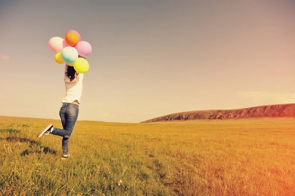 Jovem correndo com balões coloridos — Fotografia de Stock