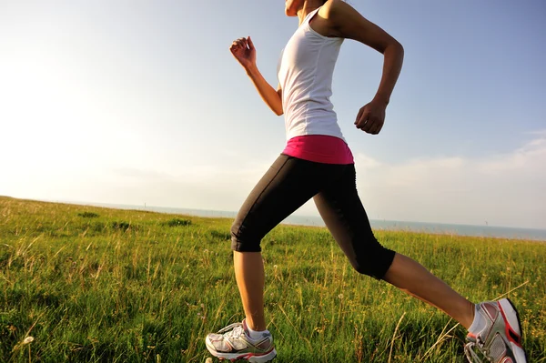 Çim sahil üzerinde çalışan runner atlet. — Stok fotoğraf