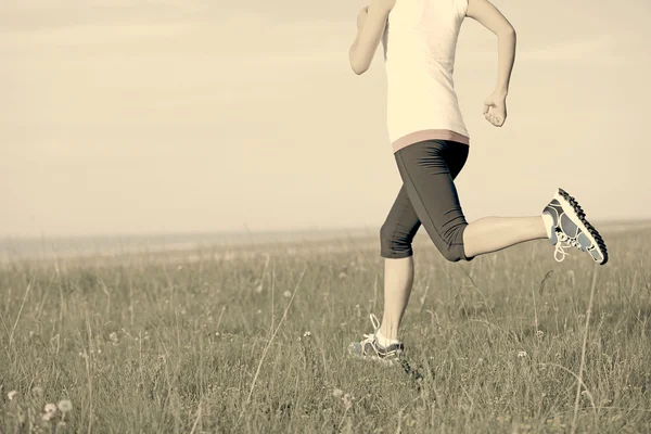 Atleta corridore che corre sull'erba sul mare . — Foto Stock