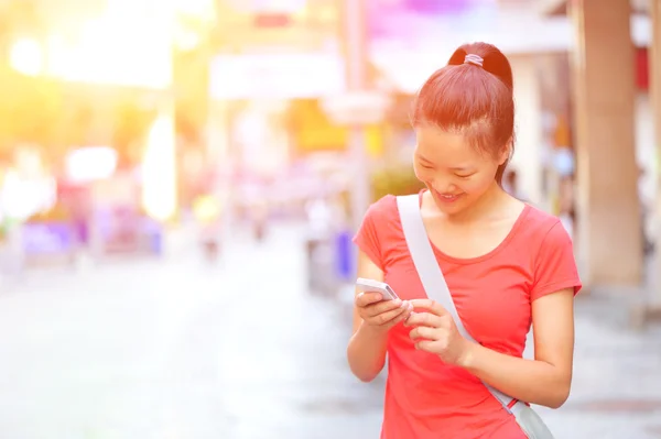 Junge asiatische Frau mit ihrem Smartphone — Stockfoto