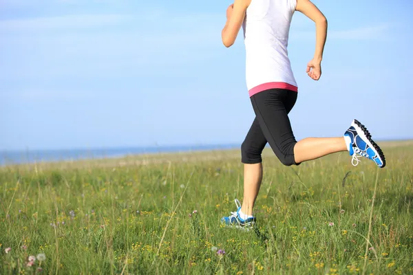 Atleta corridore che corre sull'erba sul mare . — Foto Stock