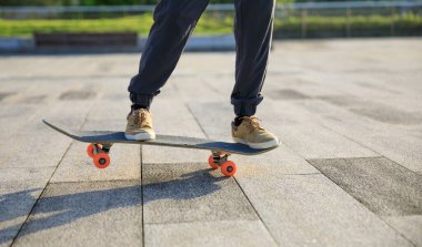 Kaykaycı şehir dışında kaykay yapıyor.