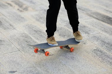 Kaykaycı şehir dışında kaykay yapıyor.