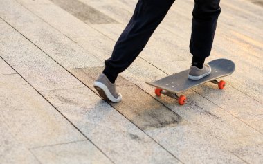 Kaykaycı şehir dışında kaykay yapıyor.