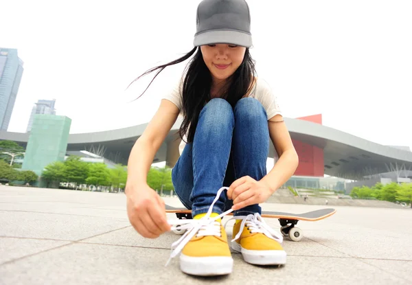 Skateboarder tying shoelace — Stock Photo, Image