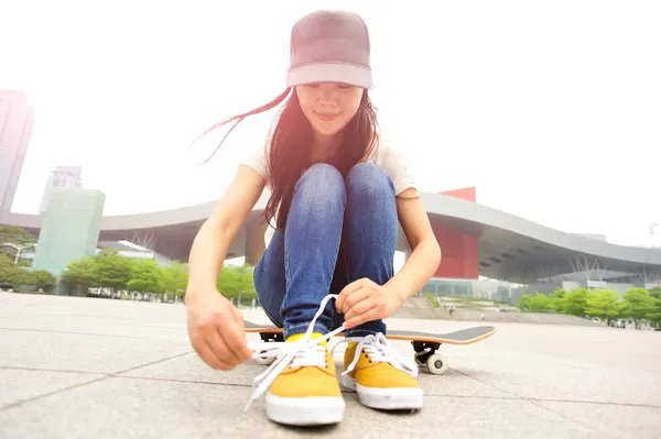 Skateboarder tying shoelace — Stock Photo, Image