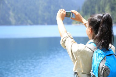 Photographer taking photo with digital camera in jiuzhaigou national park clipart
