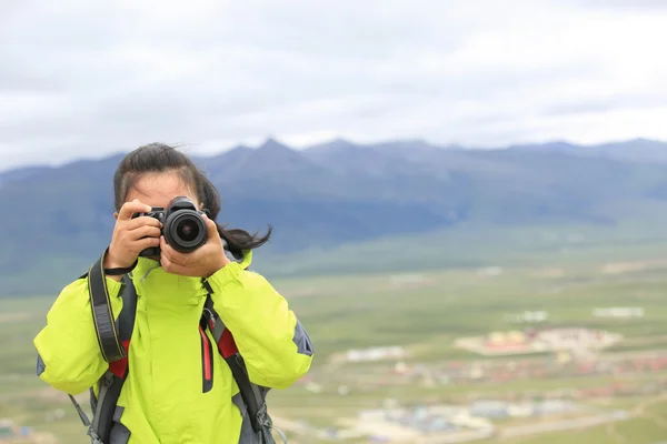 Woman photographer taking photo at plateau mountain