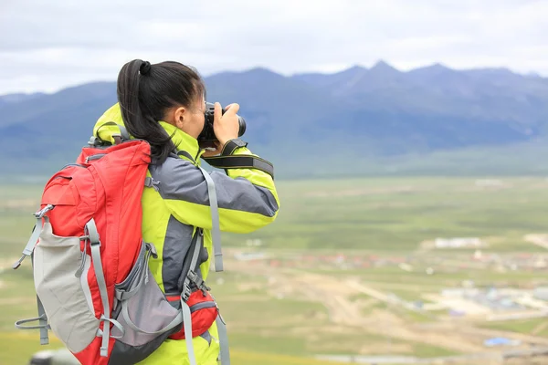 女摄影师拍照在高原山 — 图库照片