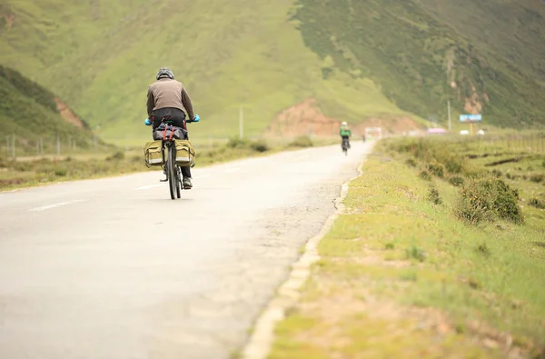 Mountain bike rides along the asphalt road — Stock Photo, Image