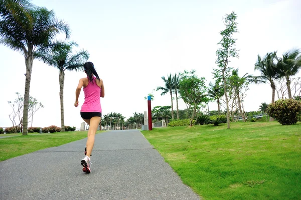 Sportovec běžec běží na tropický park. — Stock fotografie