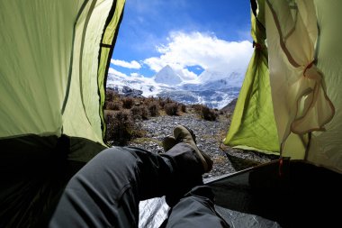 Yürüyüşçü çadırdaki güzel manzaranın tadını çıkar.