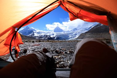 Yürüyüşçü çadırdaki güzel manzaranın tadını çıkar.