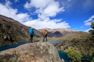 Güzel kış dağlarında yürüyüş yapan iki kadın gezgin.