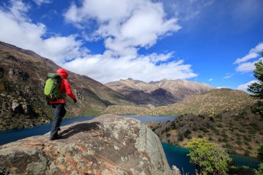Güzel kış dağlarında yürüyüş yapan bir kadın.