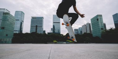 Kaykaycı şehir dışında kaykay yapıyor.